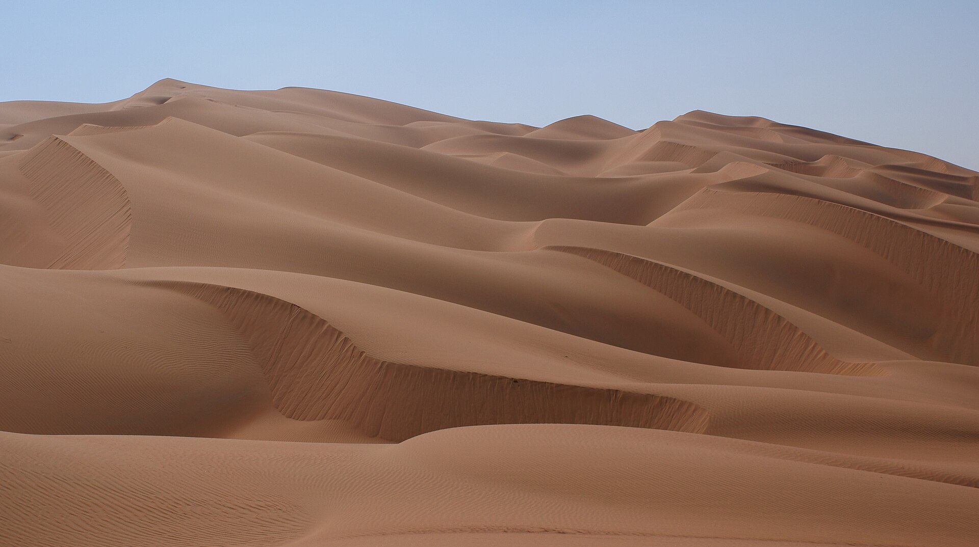 Desert highway leading toward Liwa Oasis dunes